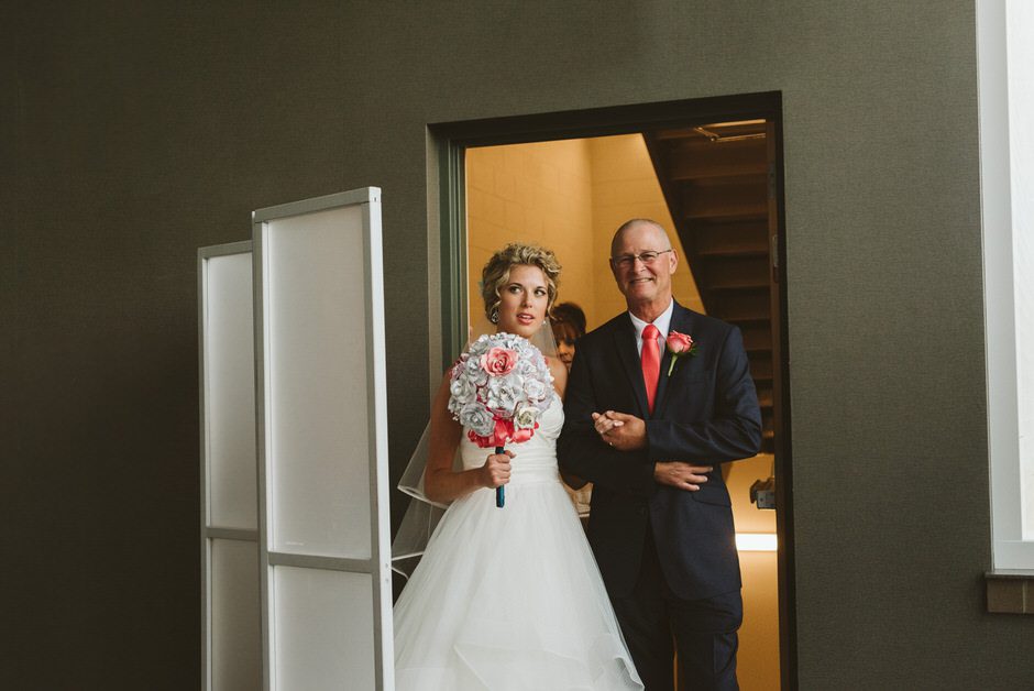 bride waiting with dad to walk down hall