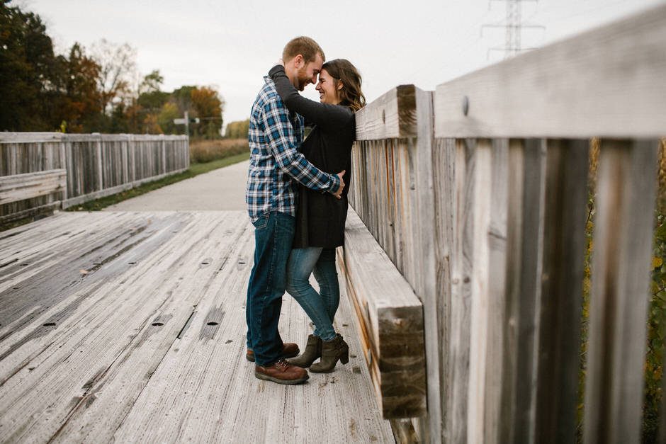 engagement photo on bridge two people hugging