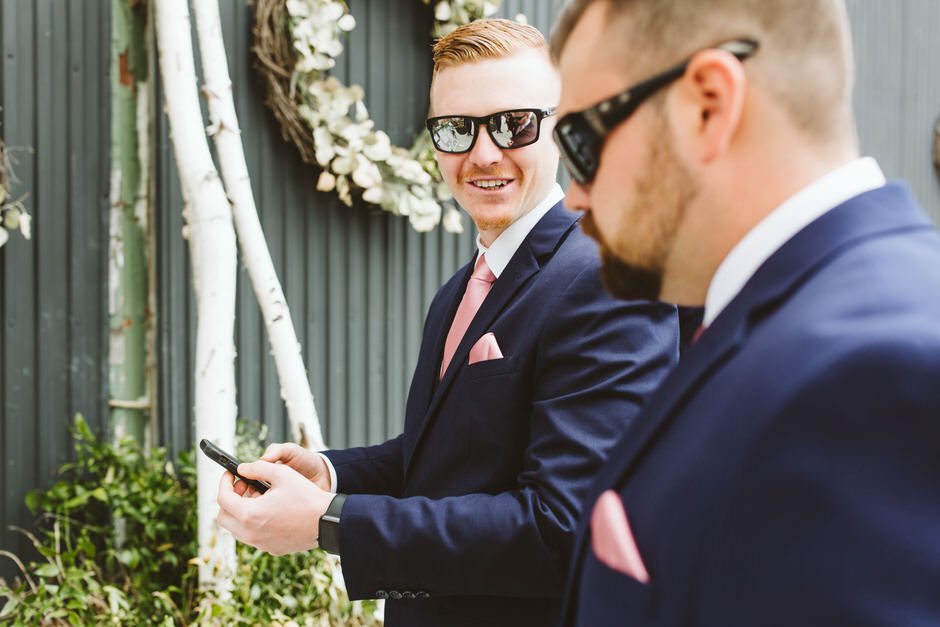 guy in blue suit with glasses showing something on his phone