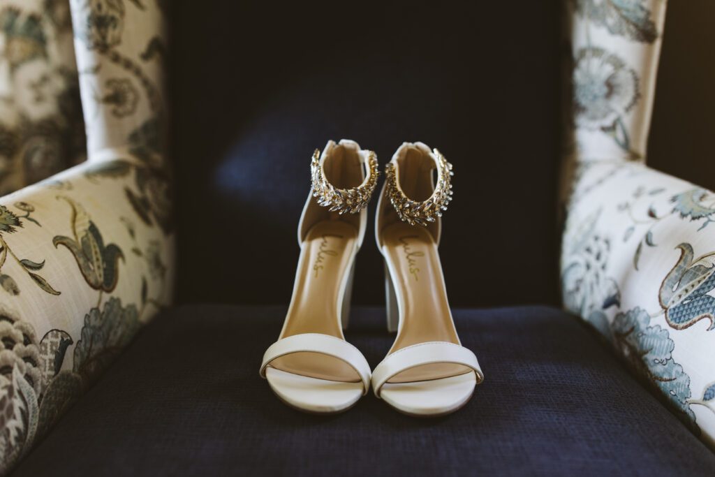 kristens shoes on a chair they have sparkley ankles and are otherwise white. 