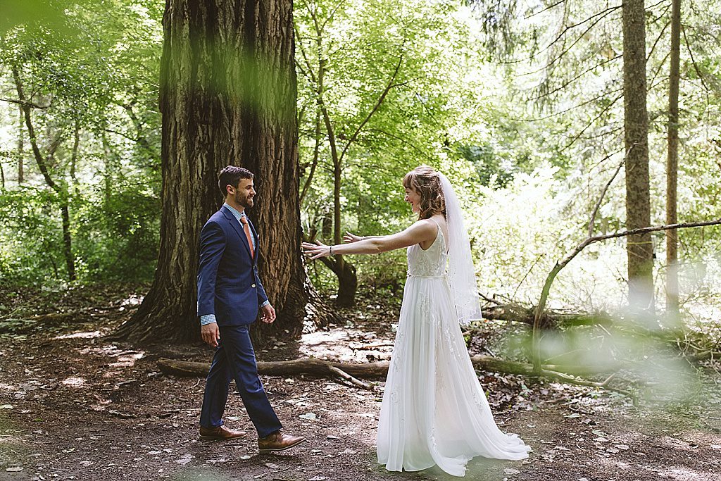 Bride and groom walking through the forest at Fenner Nature Center wedding