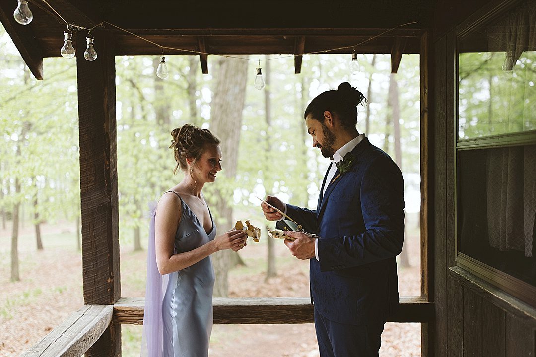 couple exchanging private vows under awning at long lake outdoor center 